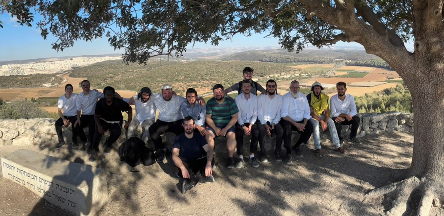 The Breslov Yeshiva talmidim gathered under a tree overlooking the hills